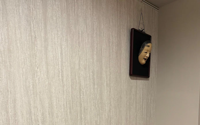 Noh mask displayed on a wall in Kyoto theater workshop.