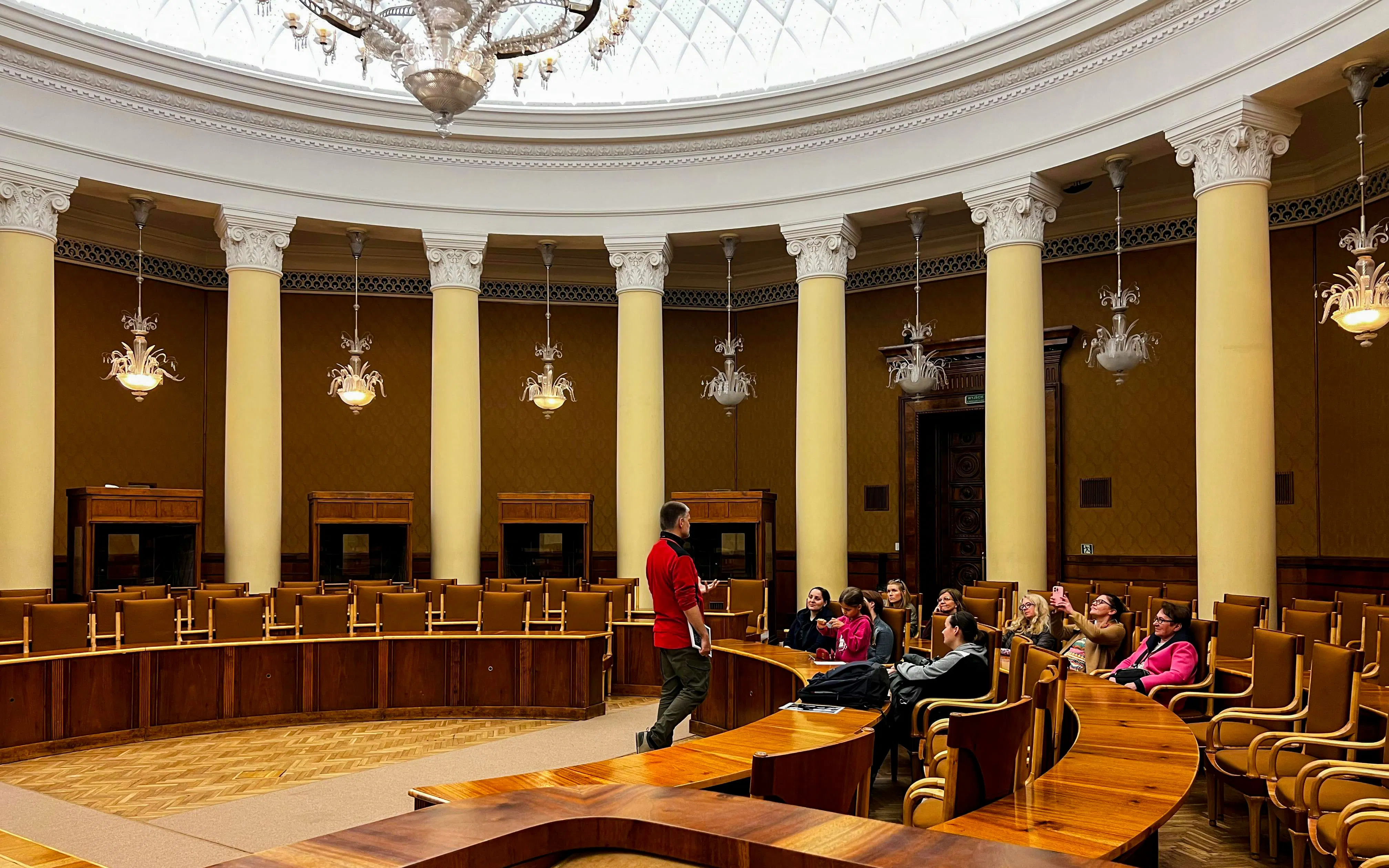 Tour group inside the Palace of Culture and Science, Warsaw, with guide speaking.