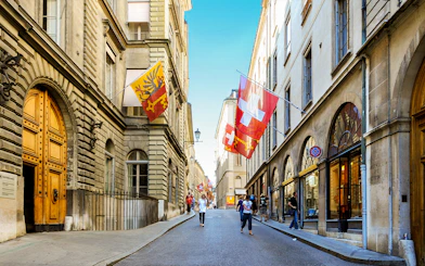 Street view in Geneva with Swiss and city flags, part of a 2-hour guided tour.