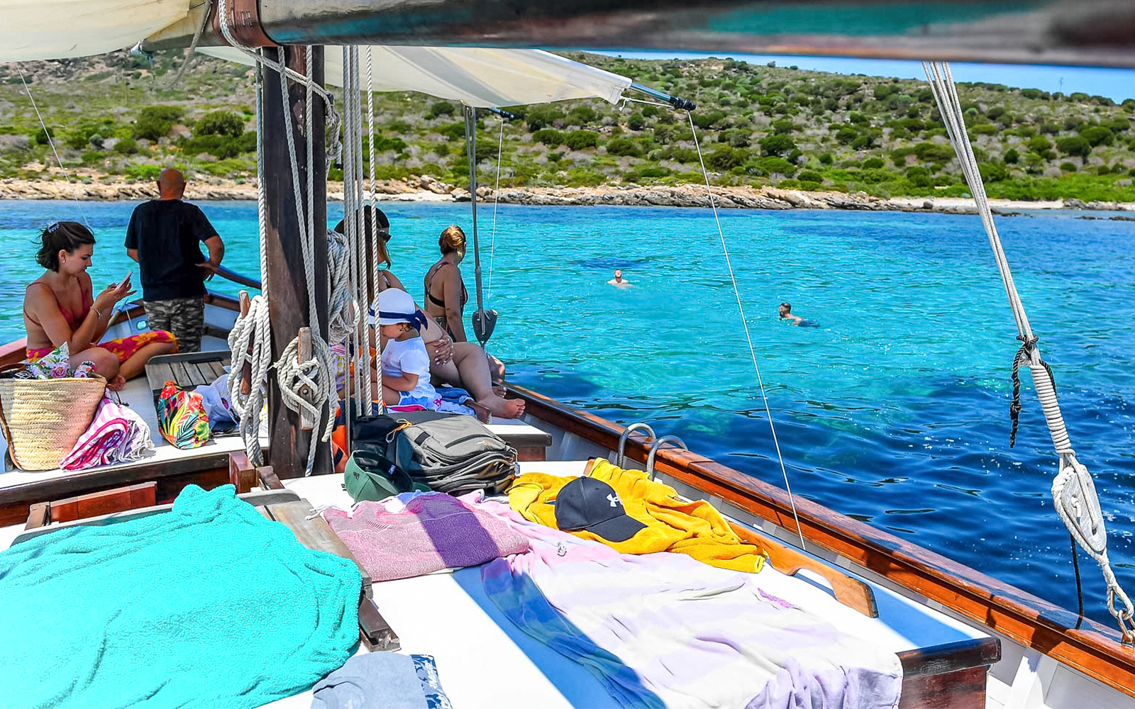 Sailboat with passengers enjoying Asinara Island's turquoise waters.