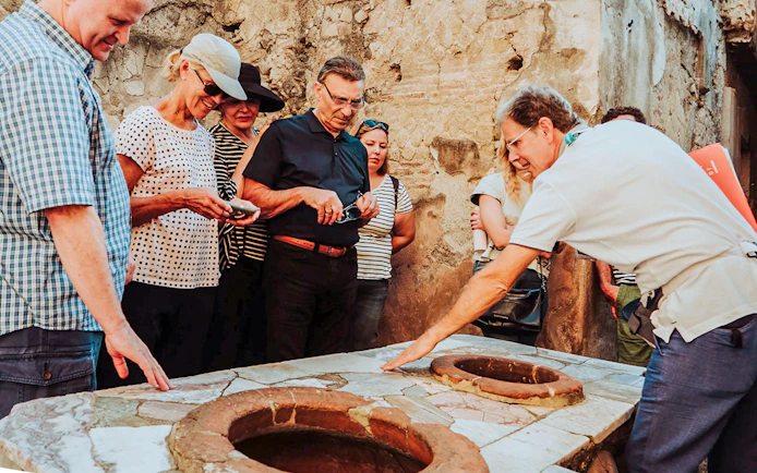 Tour group receiving expert guidance at Herculaneum archaeological site.