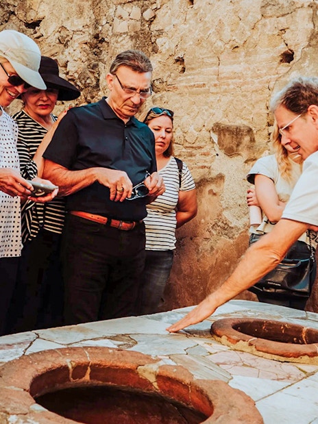 Tour group receiving expert guidance at Herculaneum archaeological site.