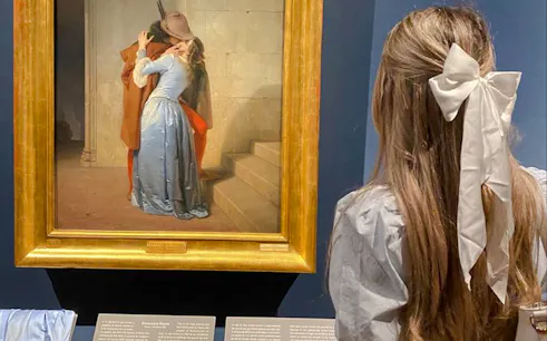 Visitor admiring "The Kiss" painting at Brera Art Gallery, Milan.