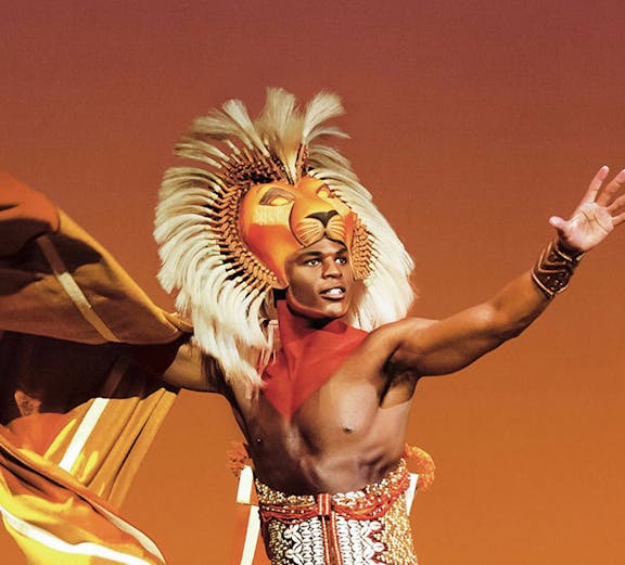 Performer in vibrant costume from a theatrical production, showcasing dynamic pose.