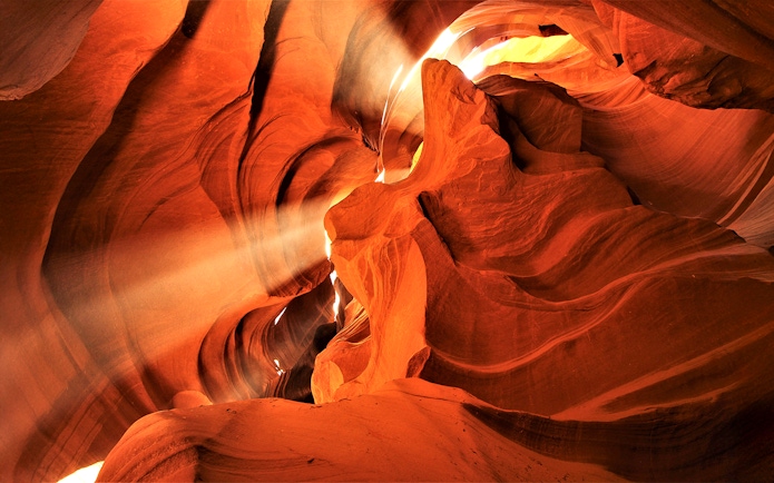 Lower Antelope Canyon's sandstone formations with sunlight beams, part of Las Vegas tour.