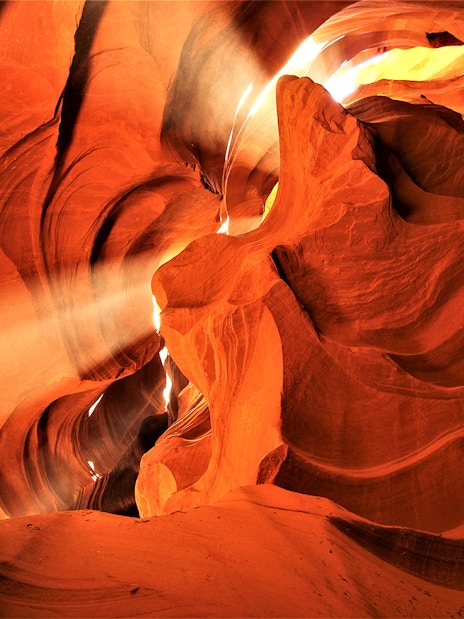 Lower Antelope Canyon's sandstone formations with sunlight beams, part of Las Vegas tour.