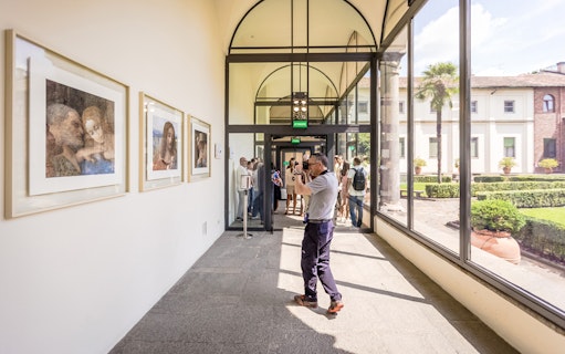 Tourists photographing art near The Last Supper in Milan, Italy.