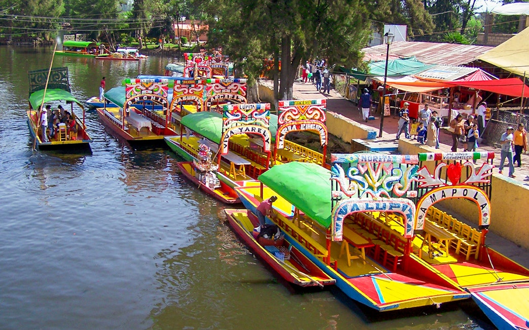 Colorful trajineras at Xochimilco boarding point, Mexico City.