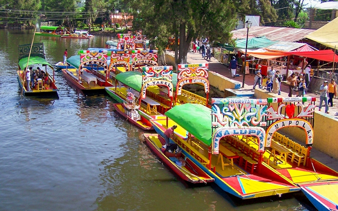 Colorful trajineras at Xochimilco boarding point, Mexico City.
