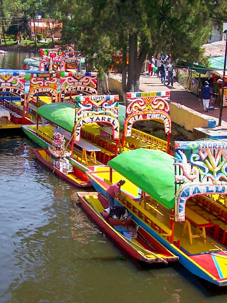 Colorful trajineras at Xochimilco boarding point, Mexico City.