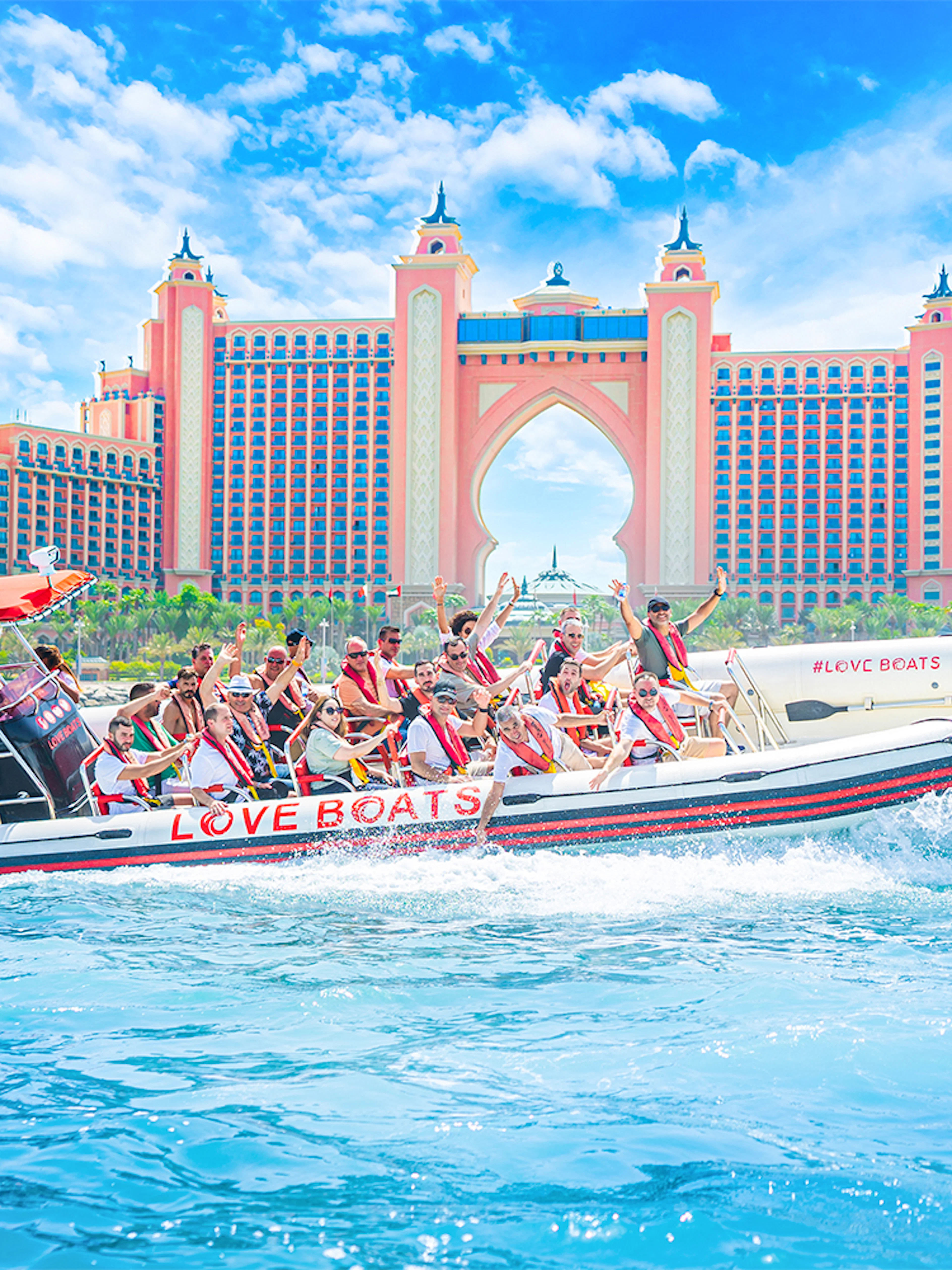 Tourists on a Love Boats speedboat near Atlantis, The Palm in Dubai.