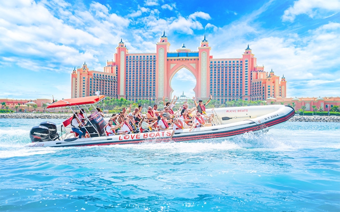 Tourists on a Love Boats speedboat near Atlantis, The Palm in Dubai.