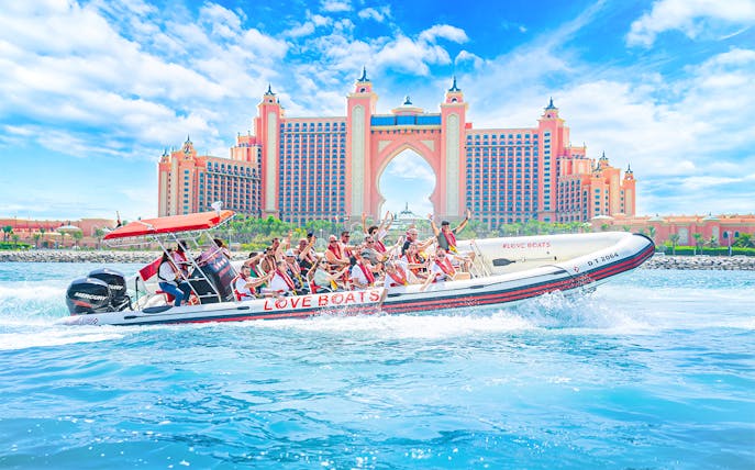 Tourists on a Love Boats speedboat near Atlantis, The Palm in Dubai.
