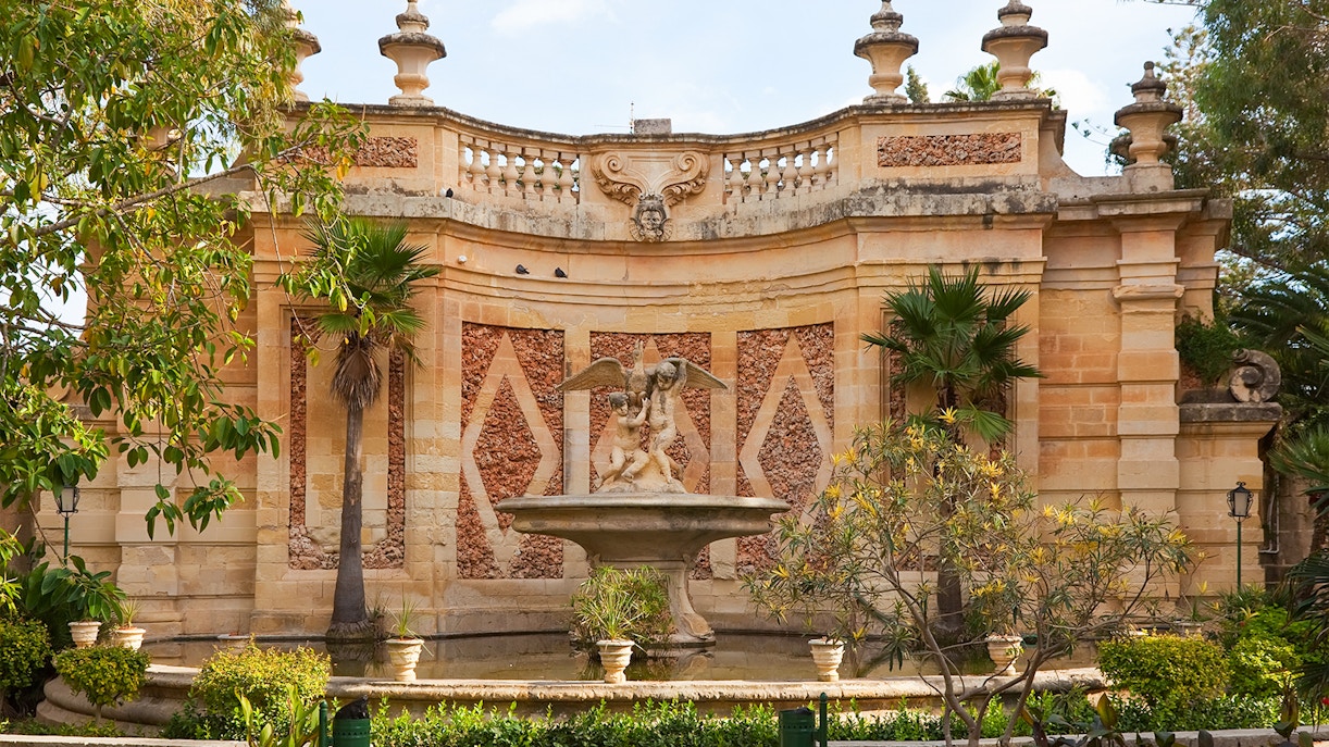 San Anton Botanical Gardens pathway with lush greenery and vibrant flowers, Mdina, Malta.