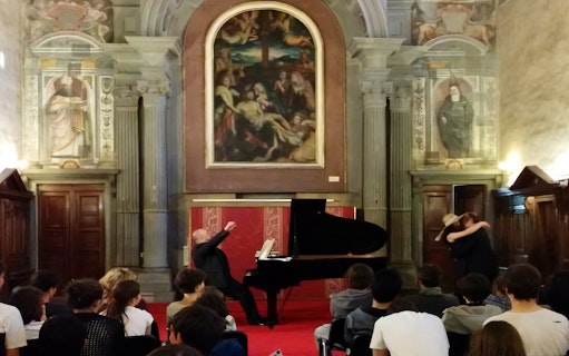 Opera singer performing at a grand piano in a historic Florence venue during an Opera Arias Concert.