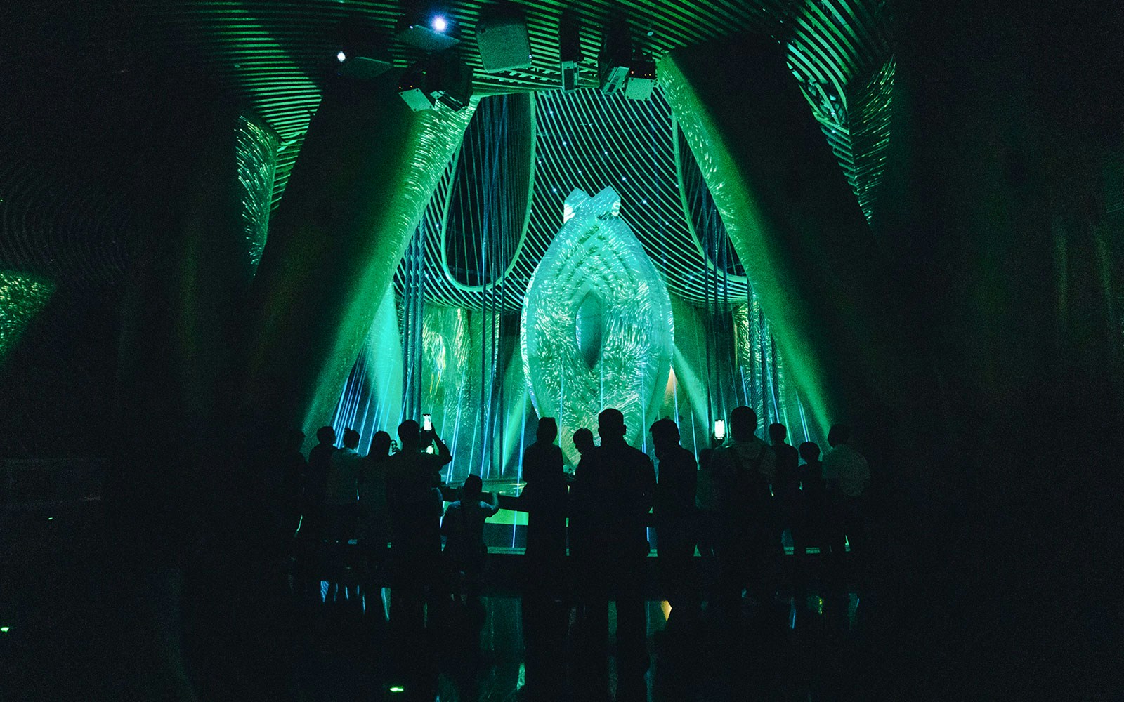 Silhouetted visitors inside Shanghai Tower's illuminated exhibit.