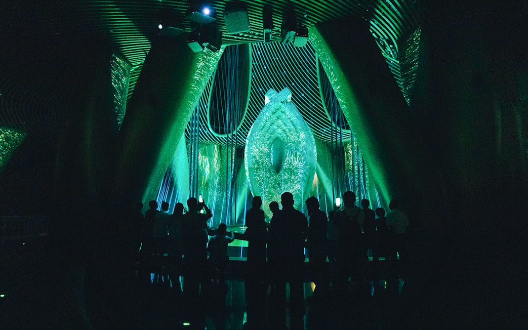 Silhouetted visitors inside Shanghai Tower's illuminated exhibit.