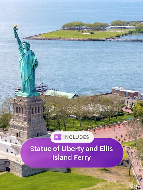 Statue of Liberty on Liberty Island with Ellis Island ferry in New York Harbor.