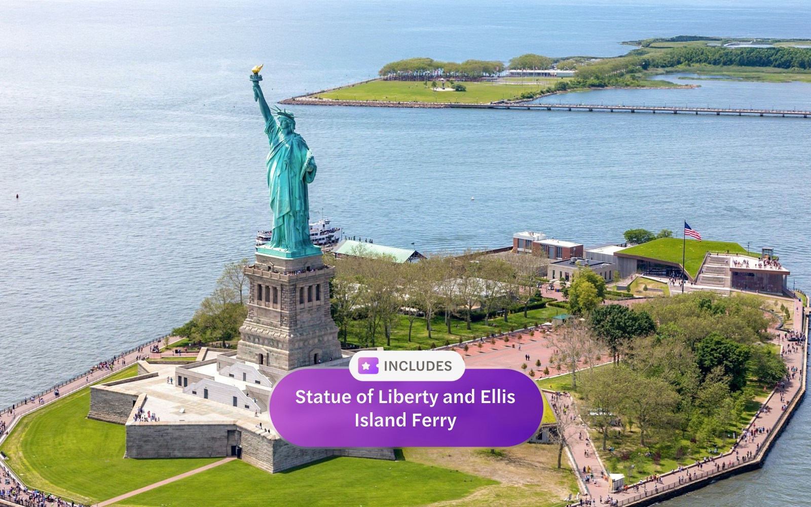 Statue of Liberty and Ellis Island ferry approaching New York City skyline.