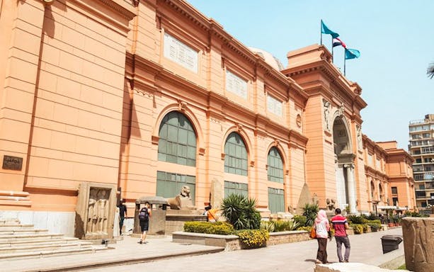 Exterior of the Egyptian Museum in Cairo with visitors exploring the entrance.