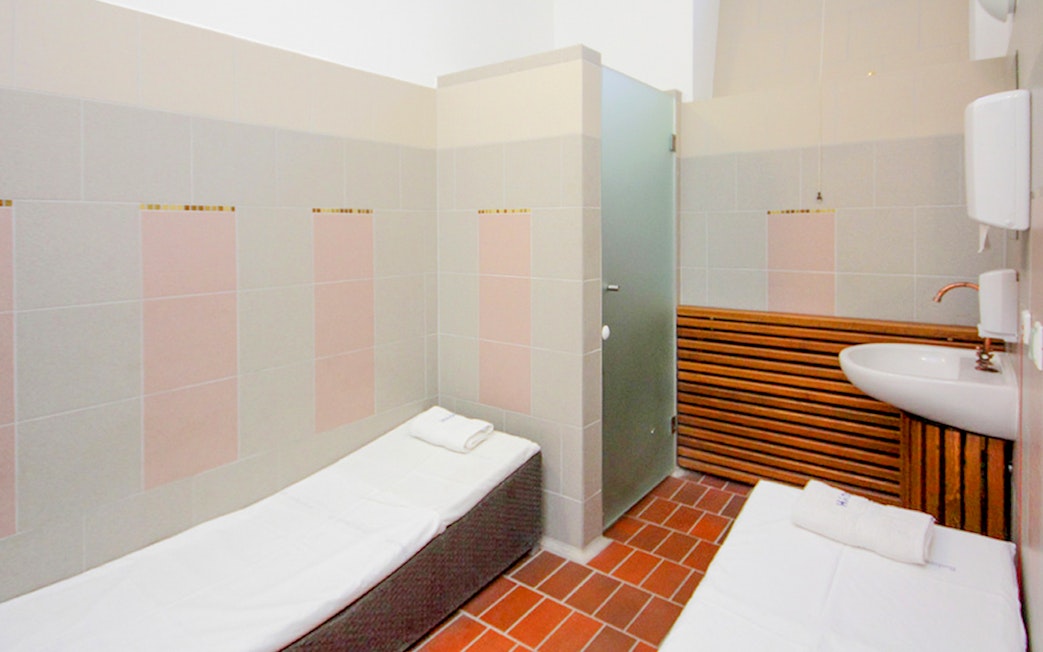 Private cabin interior at Lukacs Spa with beds and a sink.