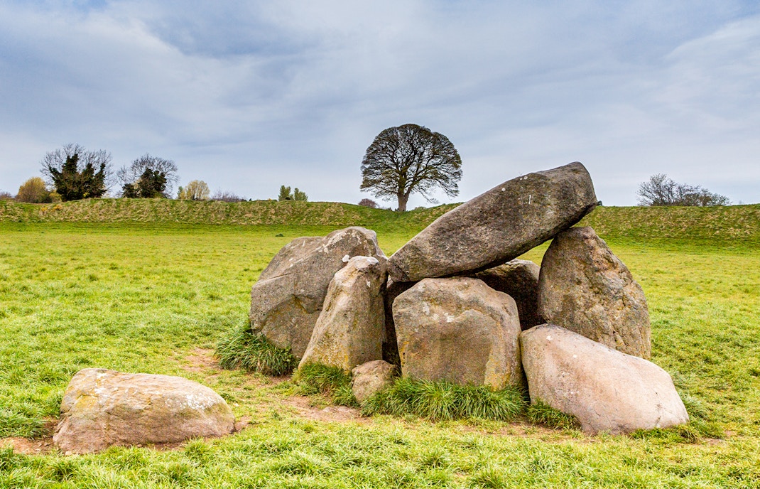 Neolithic dolmen at Giant's Ring, Belfast, surrounded by lush greenery.