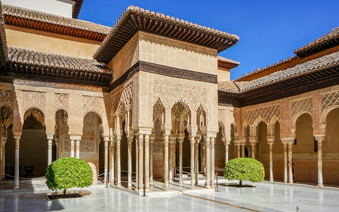 Alhambra's Nasrid Palaces courtyard with intricate arches and columns, Granada, Spain.