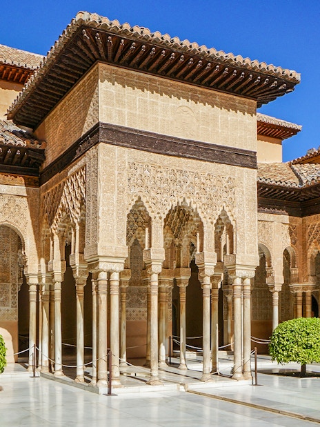 Alhambra's Nasrid Palaces courtyard with intricate arches and columns, Granada, Spain.