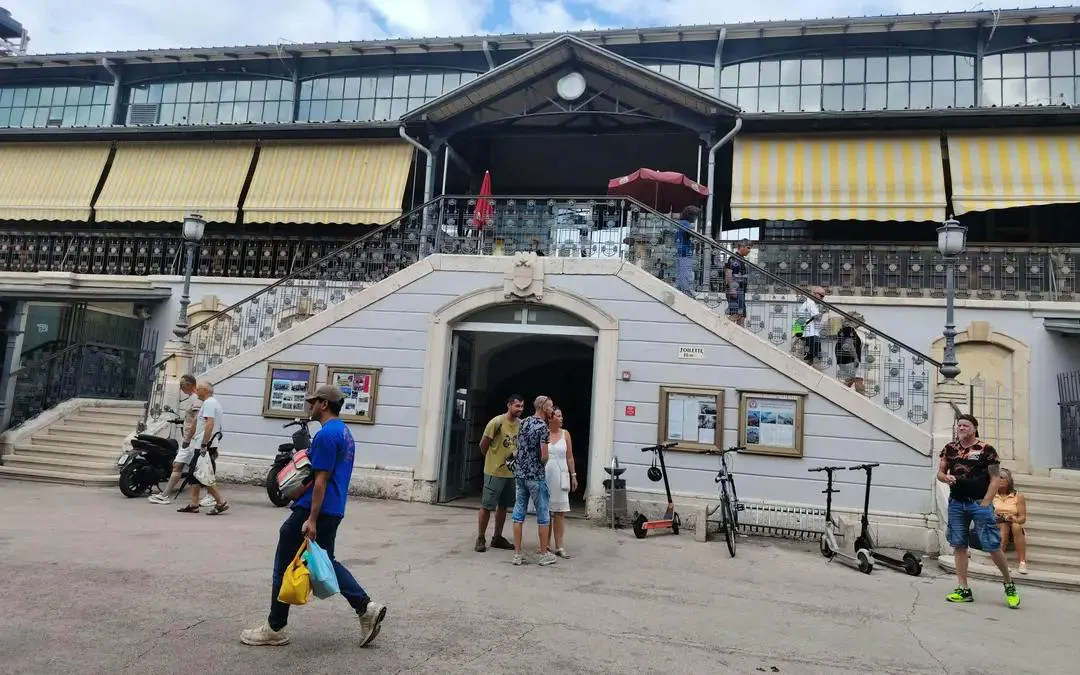 Historic building entrance with people and scooters, Pula Secret Temple exploration game, Pula.