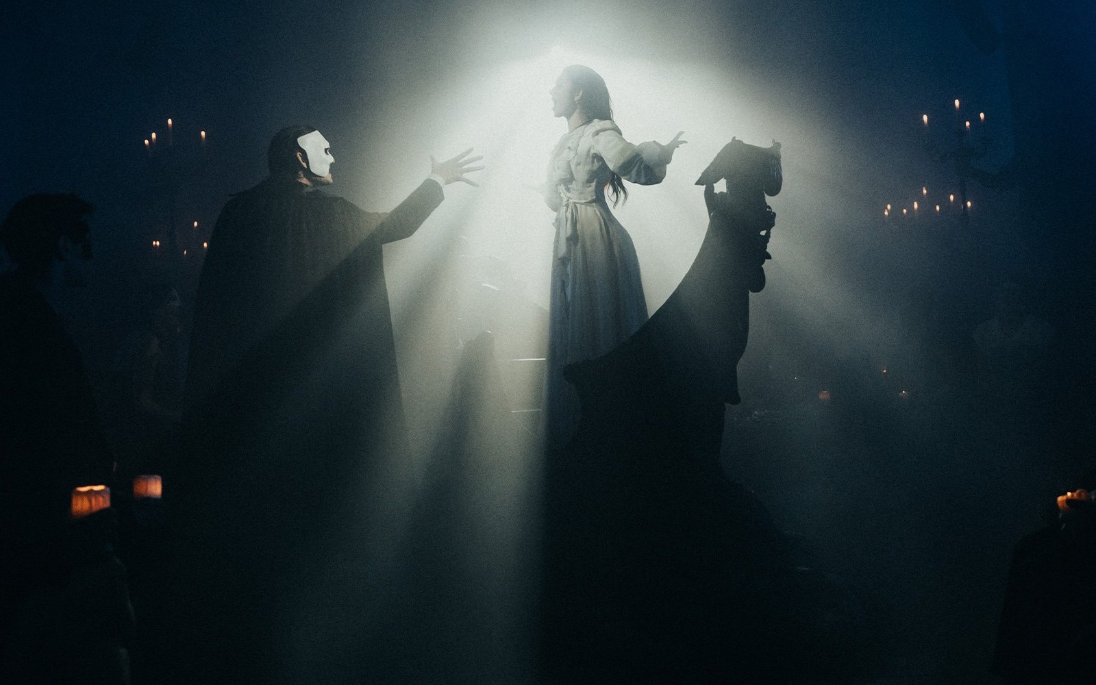 Masquerade Broadway stage performance with actors in dramatic lighting.