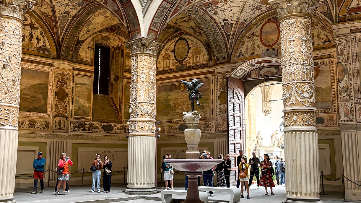 Tourists exploring the courtyard of Palazzo Vecchio, Florence, Italy.