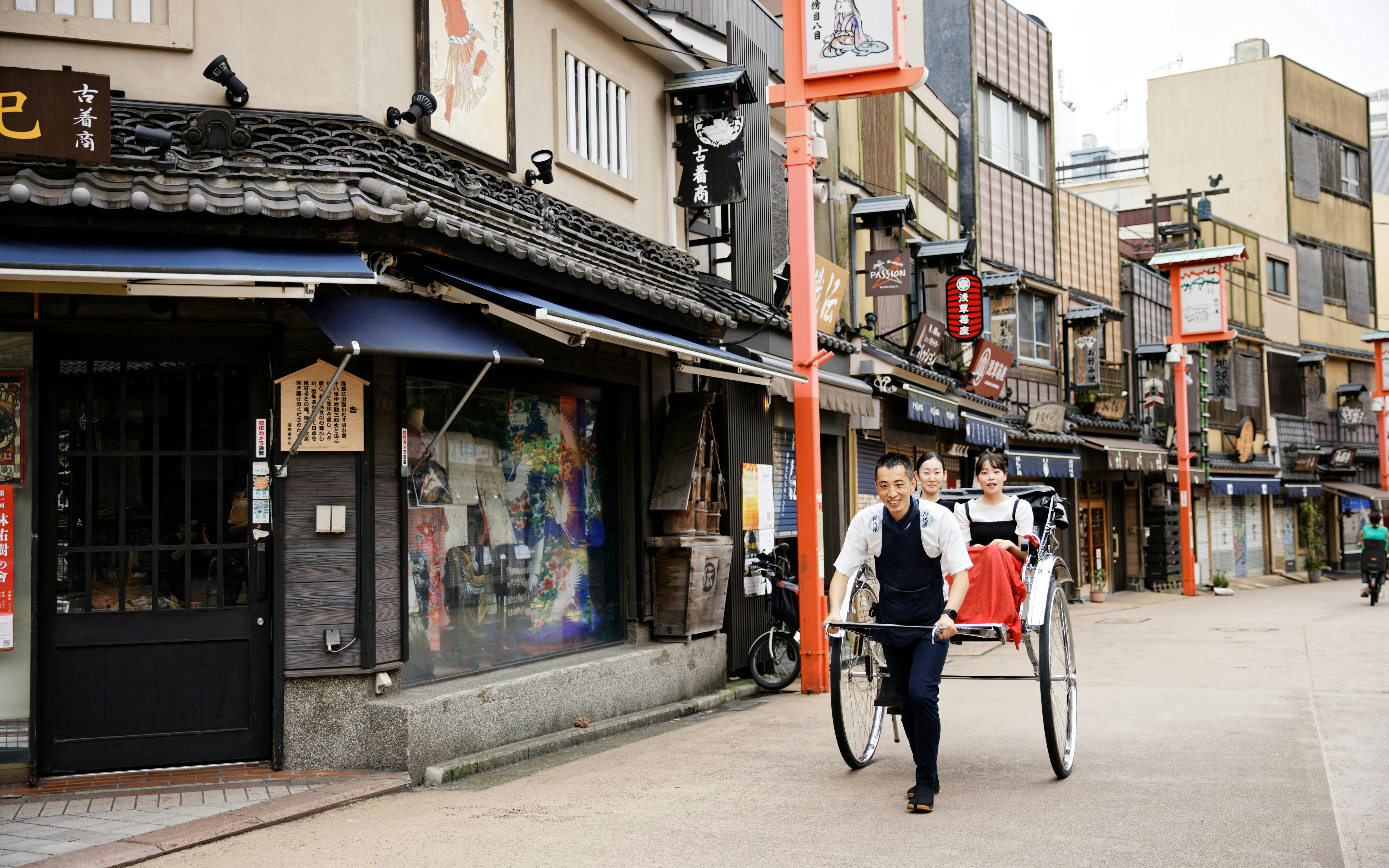 Rickshaw ride through Asakusa, Tokyo, with traditional shops in the background.