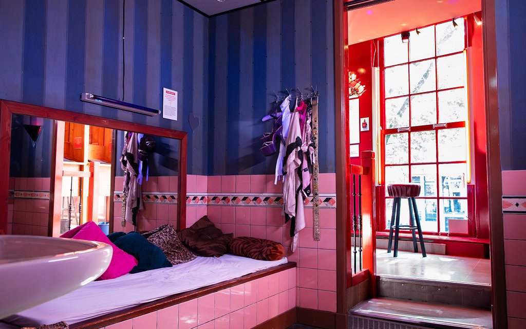 Red Light Secrets Museum room with bed, mirror, and window view.