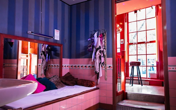 Red Light Secrets Museum room with bed, mirror, and window view.