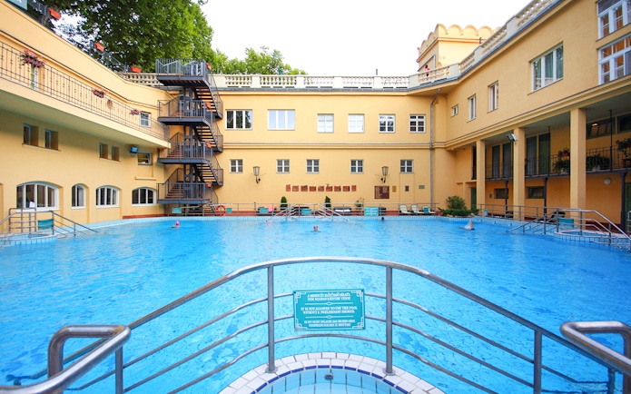 Lukacs Spa outdoor pool with historic building in Budapest, Hungary.