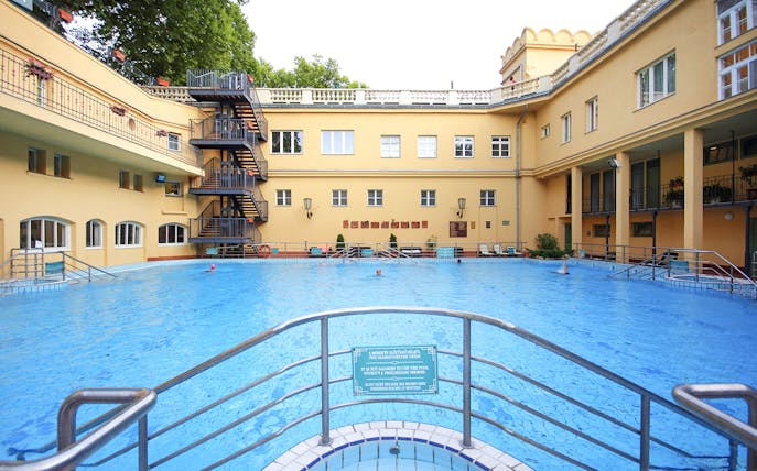 Lukacs Spa outdoor pool with historic building in Budapest, Hungary.