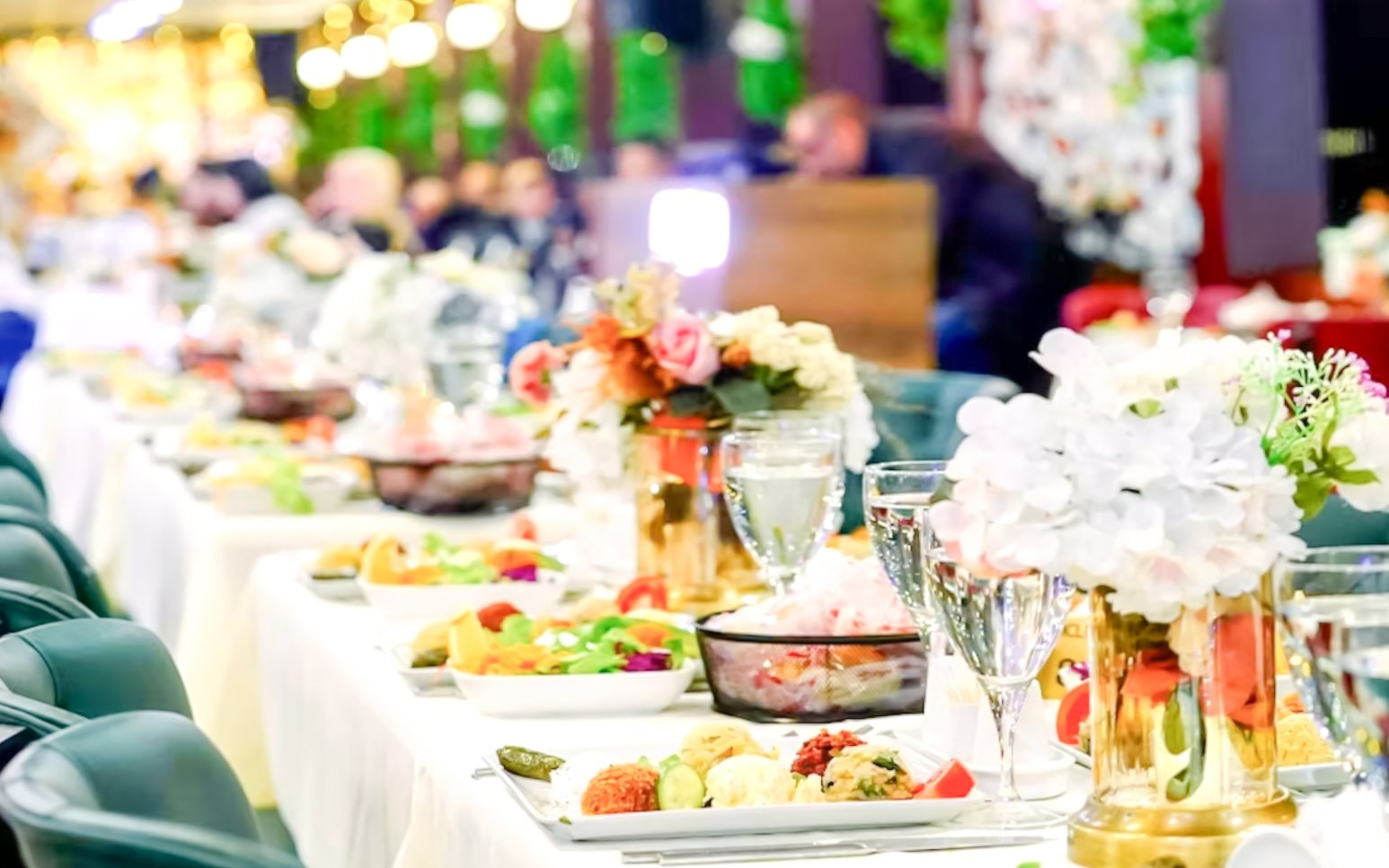 Turkish dinner setup on Bosphorus night cruise with floral centerpieces and traditional dishes.