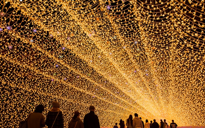 Tunnel of golden lights at Nabana no Sato, Japan, viewed by visitors, accessible with Kintetsu Rail Pass.