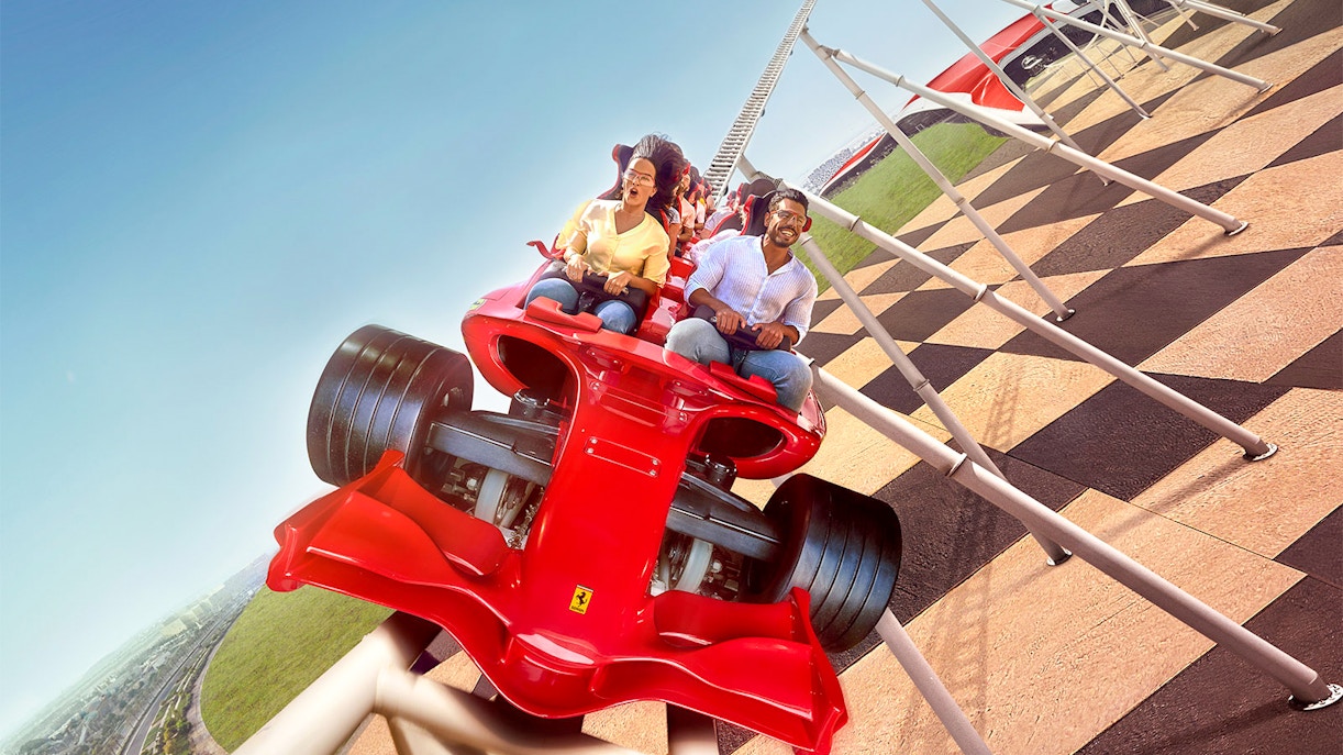 Ferrari World Abu Dhabi driving experience with shuttle, featuring iconic red Ferrari roller coaster.