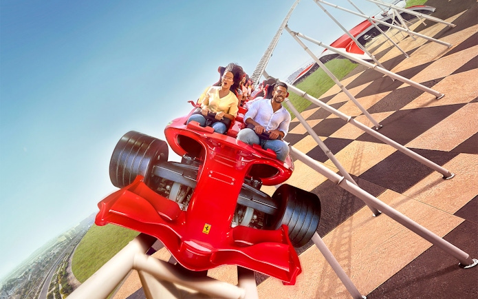 Roller coaster at Ferrari World Abu Dhabi with riders enjoying the thrill.