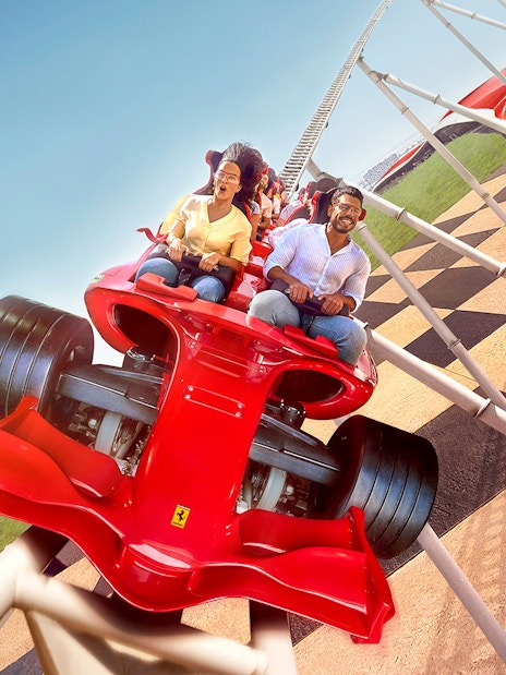 Roller coaster at Ferrari World Abu Dhabi with riders enjoying the thrill.