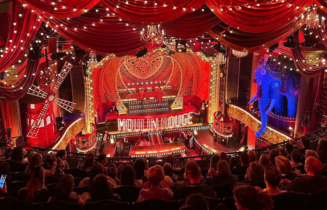 Guests watching a vibrant show at the Moulin Rouge in Paris.