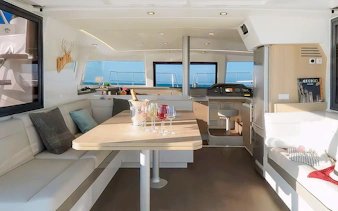 Interior of catamaran with dining area and sea view on Gdansk cruise.