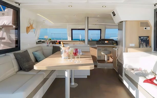 Interior of catamaran with dining area and sea view on Gdansk cruise.