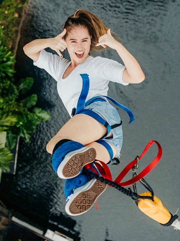 Person bungee jumping at Skypark Cairns over water.