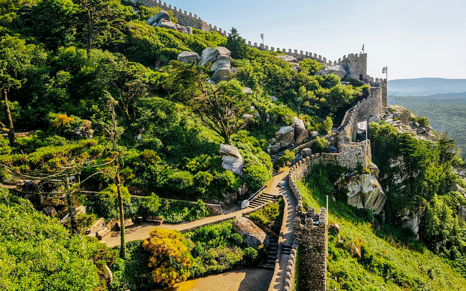 Pena Palace in Sintra with colorful turrets and lush forest surroundings.