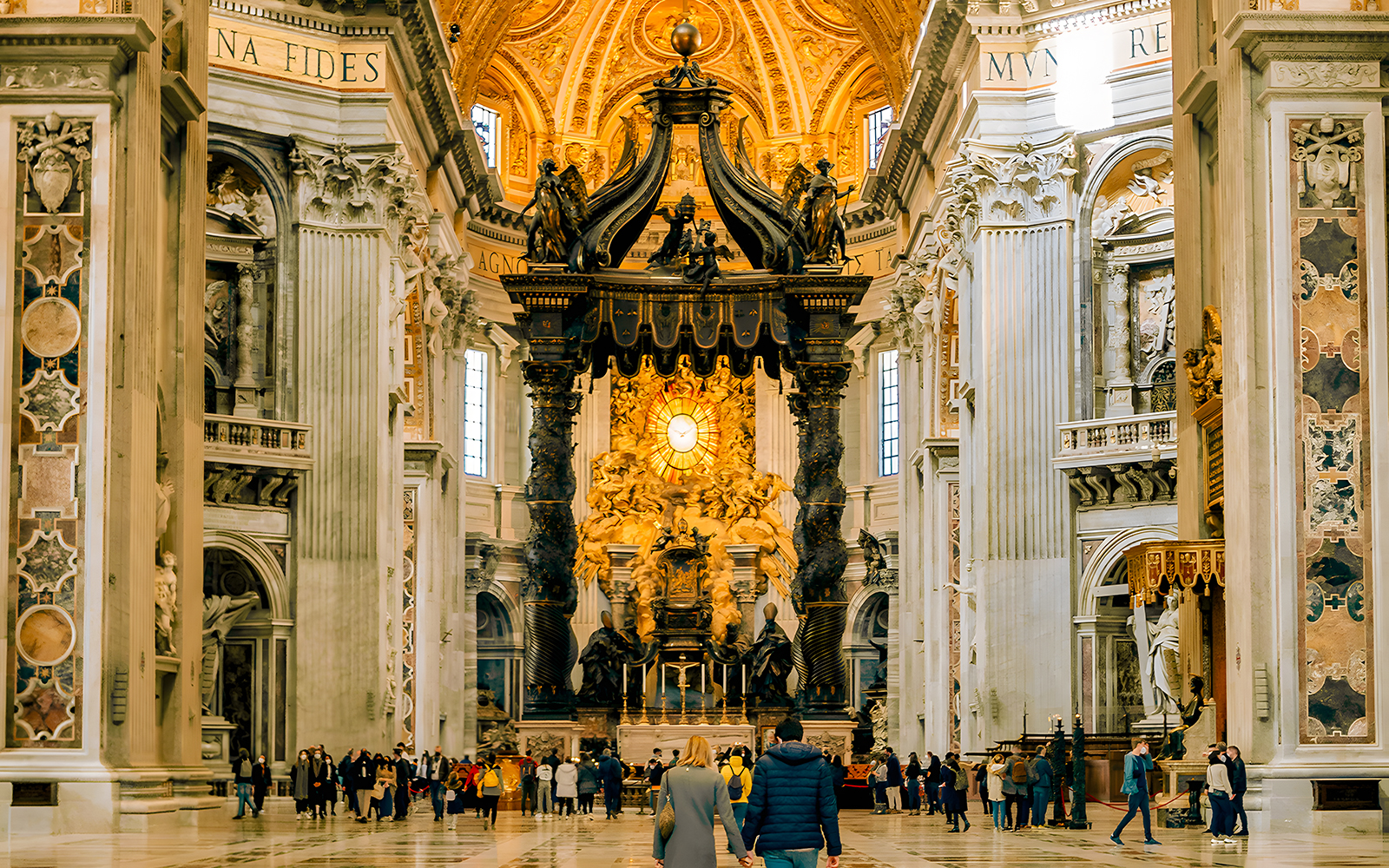 Visitors exploring the interior of St. Peter's Basilica, Vatican City, with ornate architecture and religious art.