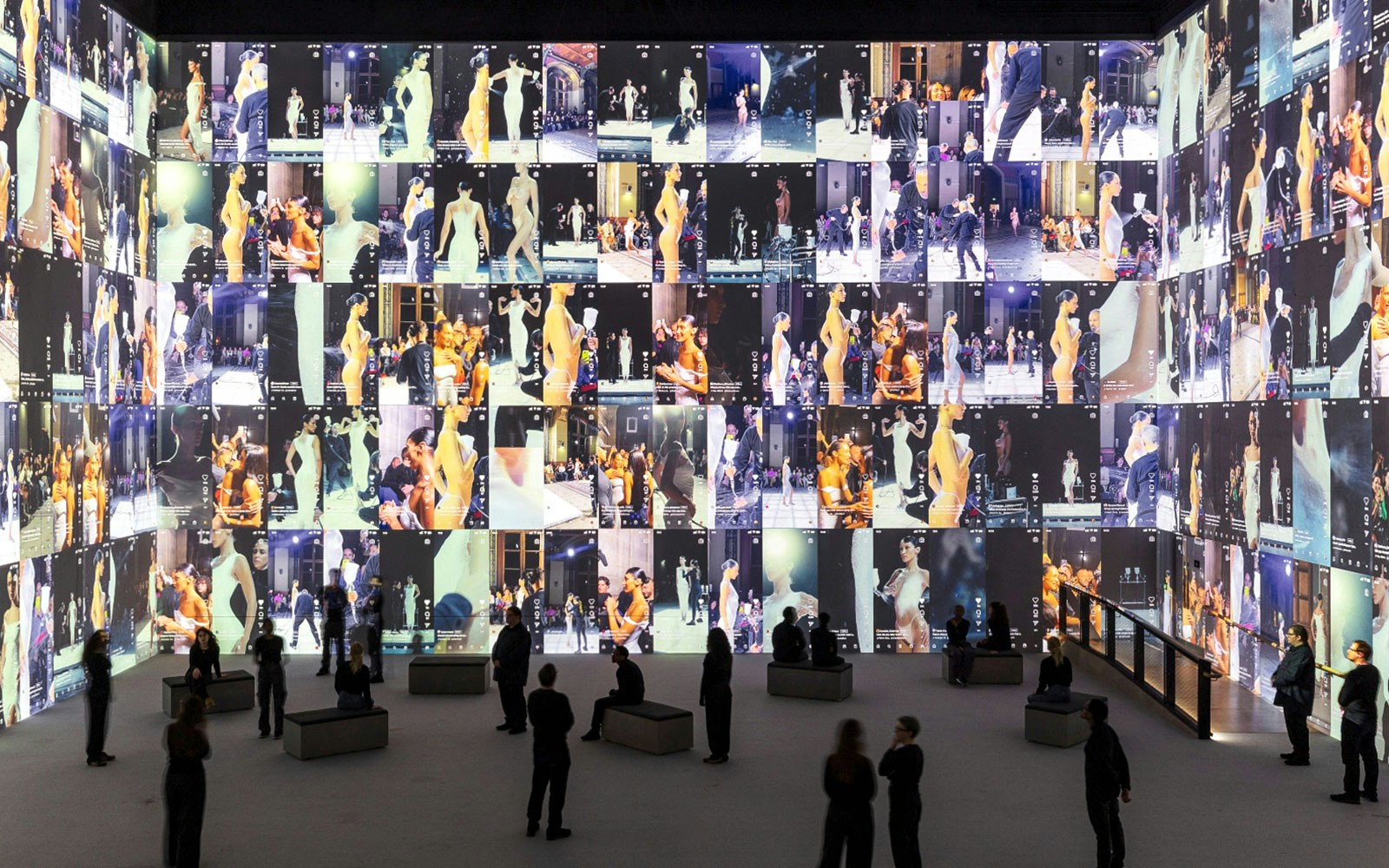 Fashion exhibit with large screens displaying runway models at Vogue: Inventing the Runway event.