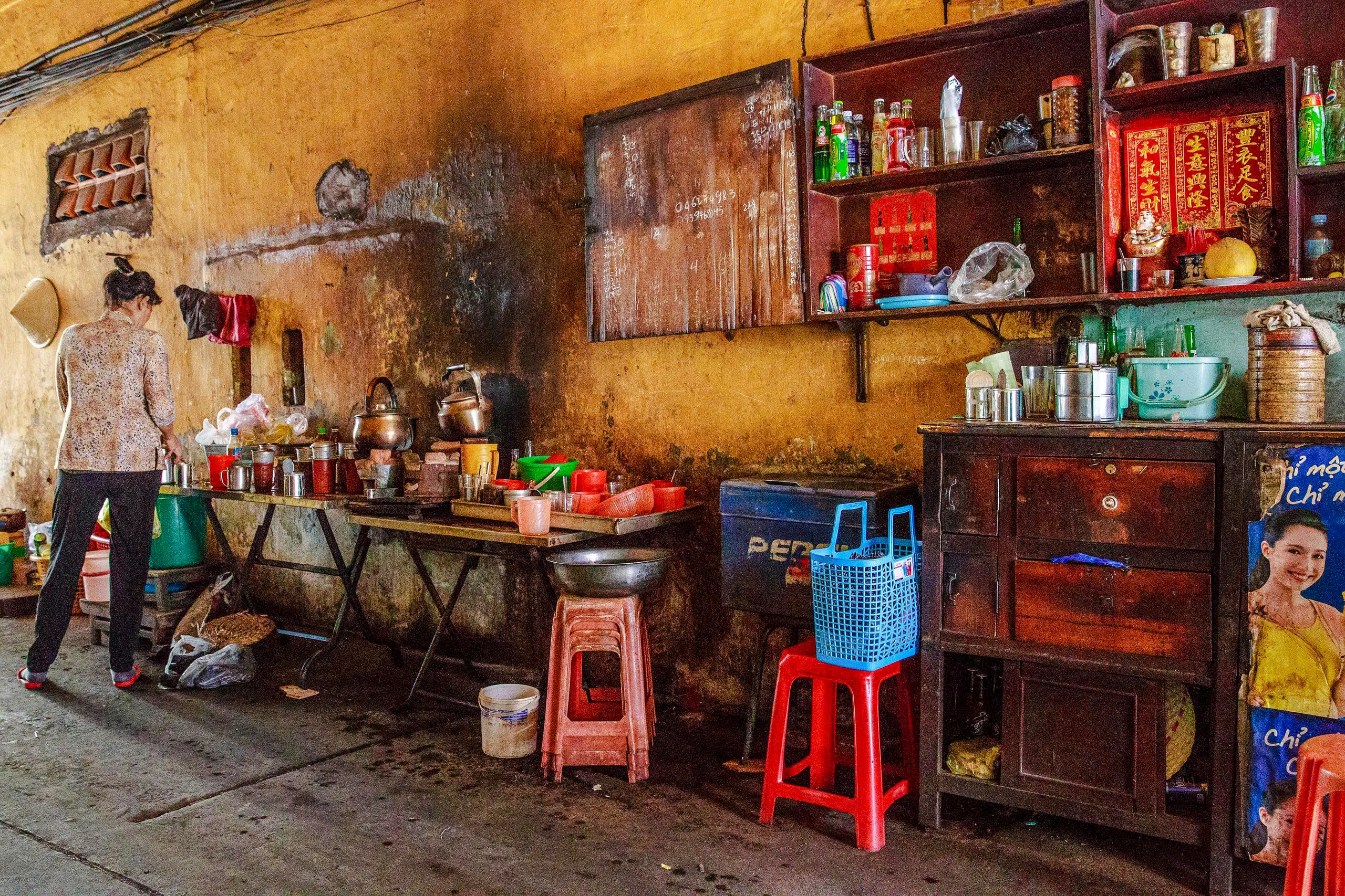 Street vendor preparing food in a rustic kitchen during Saigon Street Food Tour, Ho Chi Minh City.