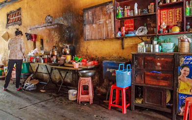 Street vendor preparing food in a rustic kitchen during Saigon Street Food Tour, Ho Chi Minh City.
